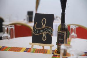 a bottle of wine sitting on a table with a sign at Hotel Résidence Essiéniguet in Abidjan