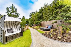 a garden with a gazebo and a couch at Wellings Parkhotel in Kamp-Lintfort
