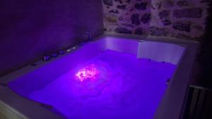 a purple bath tub with a pink light in it at Kokoro Lagoon in Saint-André-de-Sangonis +1 photo