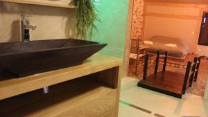 a bathroom with a black sink and a mirror at Kokoro Lagoon in Saint-André-de-Sangonis