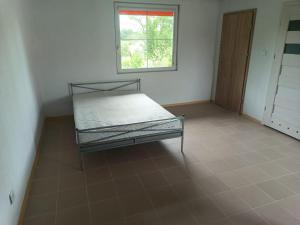 a empty room with a bed and a window at Śródziemie Erebor in Leśno