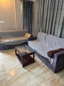 a living room with two couches and a coffee table at Willow Nest in Anachal