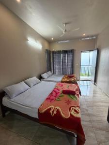 a bedroom with a large bed with a colorful blanket at Willow Nest in Anachal