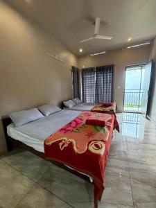 a bedroom with two beds with a red blanket at Willow Nest in Anachal