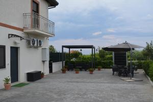 a patio with an umbrella and tables and chairs at Casa Vacanze GioApartment in Casa Toscano