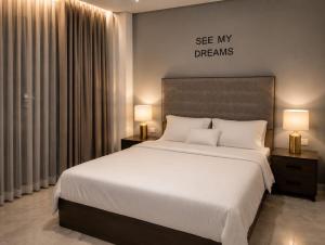a bedroom with a large white bed with two lamps at StepInn in El Alamein +6 photos