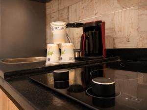 a kitchen counter with coffee cups on a tray at StepInn in El Alamein