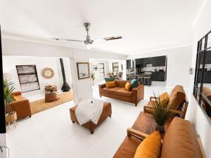 a living room with couches and a table at Tivoli House in Edgemead