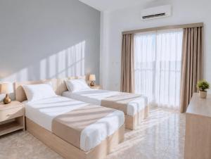 a hotel room with two beds and a window at StepInn in El Alamein