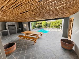 a patio with a picnic table and a pool at Tivoli House in Edgemead
