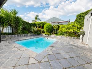 a swimming pool in the middle of a patio at Tivoli House in Edgemead