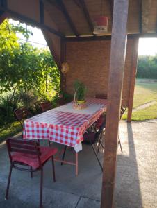 a red and white checkered table and chairs on a patio at Blossom Cottage - ''Green Energy"' in Laktaši