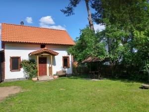 a small white house with an orange roof at Wigierska Chatka in Gawrych Ruda