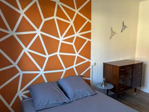a bedroom with an orange and white wall at La maison Champollion in Albi