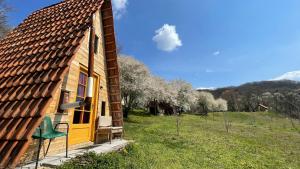 a house with a green chair sitting outside of it at Malajac Bigrenica in Bigrenica