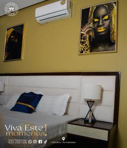 a bedroom with a bed and a picture of a woman at Hotel DPanda House in Cacuaco