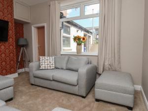 a living room with a couch and a chair and a window at Lansdowne Grange in Bridlington