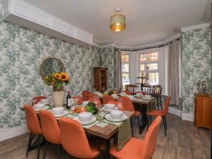 a dining room with a table and chairs and floral wallpaper at Lansdowne Grange in Bridlington