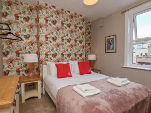 a bedroom with a bed with a floral wall at Lansdowne Grange in Bridlington