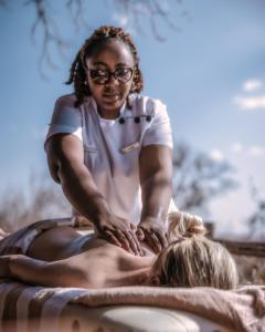 a woman getting a massage from a therapist at Tarangire Treetops in Kwa Kuchinia