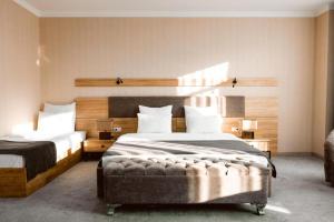 a bedroom with two beds and a headboard at Valor Hotel in Tashkent +27 photos