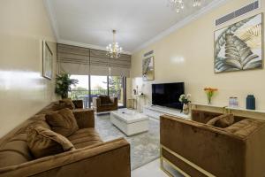 a living room with a large couch and a tv at Bloomfields 2BR+Maid in Mina Fajer - Fujairah in Fujairah