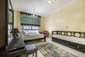 a bedroom with two beds and a desk and a window at Bloomfields 2BR+Maid in Mina Fajer - Fujairah in Fujairah