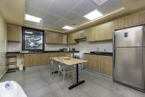 a large kitchen with a table and a refrigerator at Bloomfields 2BR+Maid in Mina Fajer - Fujairah in Fujairah