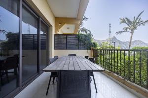 a wooden table and chairs on the balcony of a house at Bloomfields 2BR+Maid in Mina Fajer - Fujairah in Fujairah