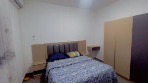 a bedroom with a bed with a blue comforter at Maison d'hôtes Jaxaay in Keur Massar