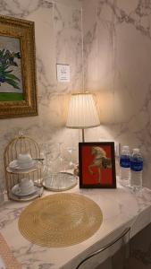 a table with a lamp and a picture of a horse on it at The Atlantic Langkawi in Pantai Cenang