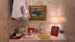 a table with a lamp and a picture on a wall at The Atlantic Langkawi in Pantai Cenang