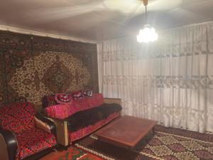 a living room with a couch and a table at Guesthouse Adis in Kyzart