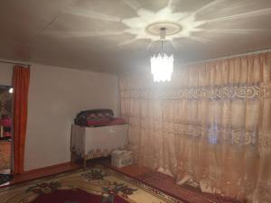 a room with a ceiling fan and a window with a curtain at Guesthouse Adis in Kyzart