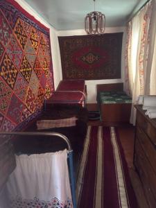 a living room with two beds and a wall with patterns at Guesthouse Adis in Kyzart