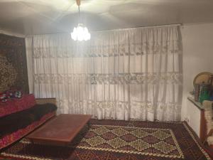 a living room with a couch and a window at Guesthouse Adis in Kyzart