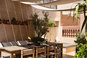 an outdoor patio with a wooden table and chairs at Riad Solange in Marrakesh