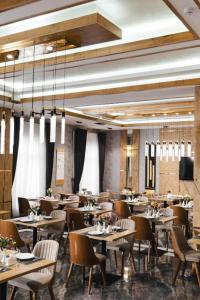 a restaurant with tables and chairs in a room at Valor Hotel in Tashkent