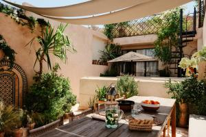 an outdoor patio with a table and some plants at Riad Solange in Marrakesh