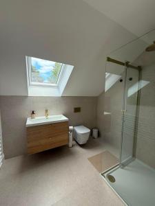 a bathroom with a sink and a shower with a skylight at Cour Cottage in Drem +14 photos