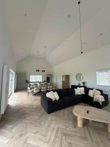 a living room with a black couch and a table at Cour Cottage in Drem