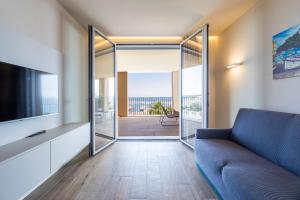 a living room with a blue couch and a balcony at VillaPignone in Genoa