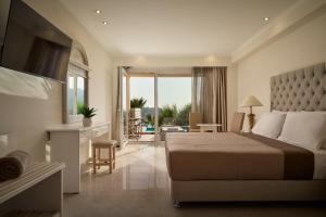a bedroom with a bed and a living room at Paleokastritsa Palace - Adults Only in Paleokastritsa
