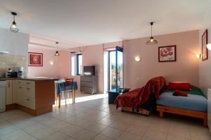 a bedroom with a bed and a kitchen with a counter at Les Chouettes - Au Soleil Breton in Saint-Nic