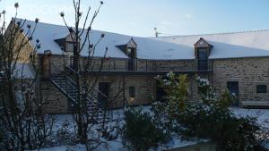 a brick building with a staircase in the snow at Les Chouettes - Au Soleil Breton in Saint-Nic +6 photos