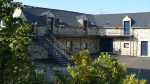 a building with a staircase on the side of it at Les Chouettes - Au Soleil Breton in Saint-Nic