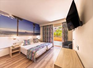 a hotel room with a bed and a flat screen tv at Hotel Tropic in Cala de Finestrat