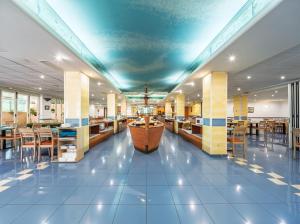a restaurant with blue ceilings and tables and chairs at Hotel Tropic in Cala de Finestrat