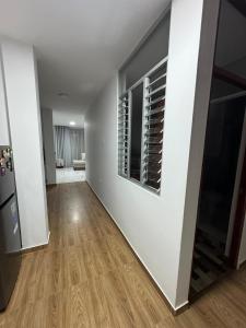 an empty living room with white walls and wood floors at Depa Ángel in Moyobamba