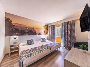 a hotel room with a bed and a flat screen tv at Hotel Tropic in Cala de Finestrat